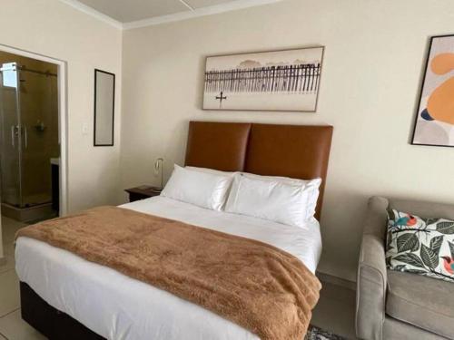 a bedroom with a large bed and a couch at Executive Modern Apartment in Fourways