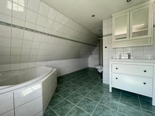 y baño con bañera, lavabo y aseo. en Hostel DünenMeer en Kühlungsborn