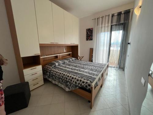 een slaapkamer met een bed en een groot raam bij Musto House in Albenga