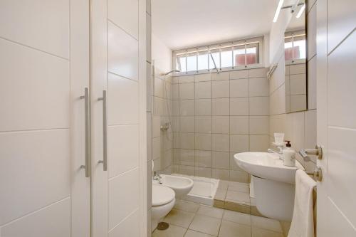een witte badkamer met een toilet en een wastafel bij Casa Médano 19 By Médano Rentals in El Médano