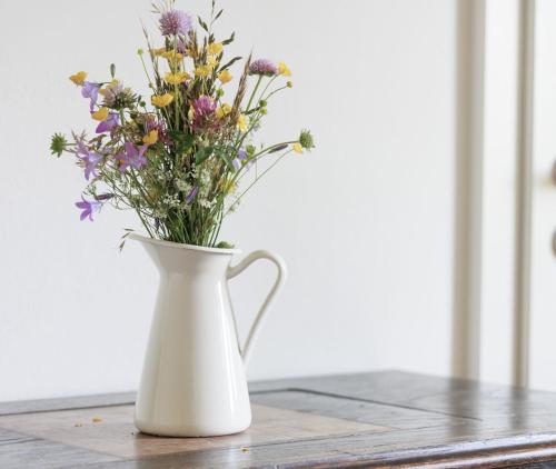 a white vase filled with flowers on a table at Bauernhof Kure in Leutschach