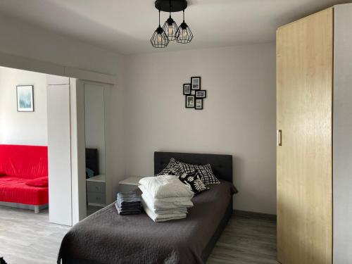 a bedroom with a bed and a red couch at Apartament Gdynia Warszawska in Gdynia