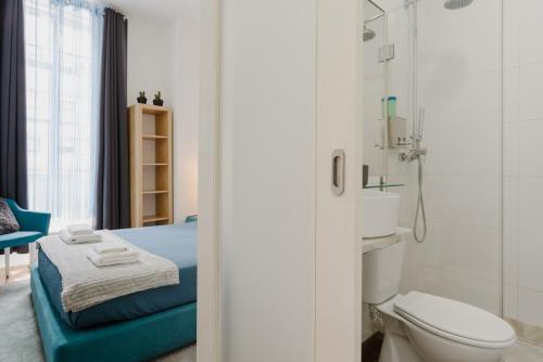 y baño con cama, aseo y ducha. en Ndussole Guest House, en Oporto