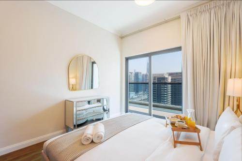 Chic 1BR Next to Dubai Marina Promenade by Livbnb في دبي: غرفة نوم بسرير كبير ونافذة كبيرة