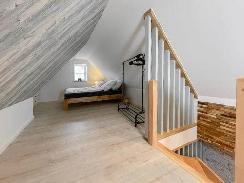 1 dormitorio con 1 cama y escaleras en un ático en Lüttjet Huus, en Lügde