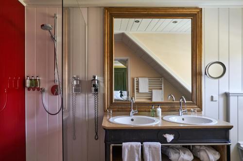 a bathroom with two sinks and a large mirror at Relais & Châteaux Hardenberg BurgHotel in Nörten-Hardenberg