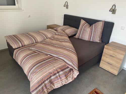 ein Bett mit einer Bettdecke und Kissen darauf in der Unterkunft Kleine Ferienwohnung Nähe Amstetten in Spiegelsberg