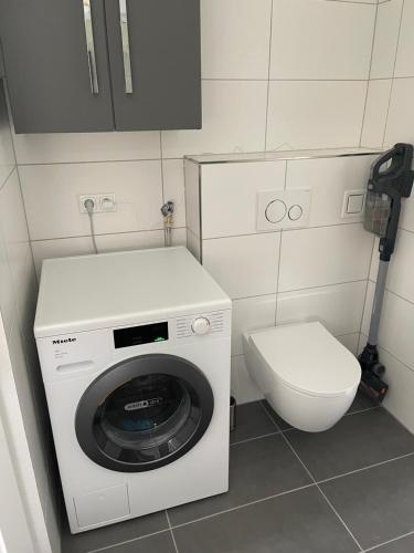 a bathroom with a washing machine and a toilet at Kleine Ferienwohnung Nähe Amstetten in Spiegelsberg