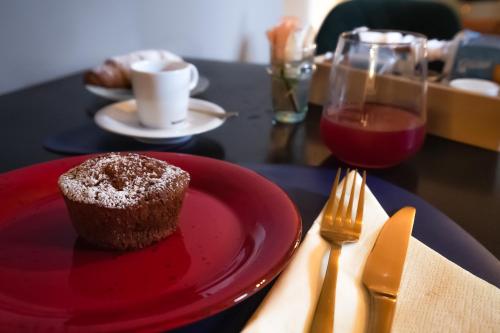 a red plate with a chocolate muffin and a glass of wine at La Sosta in Toscana in Camaiore
