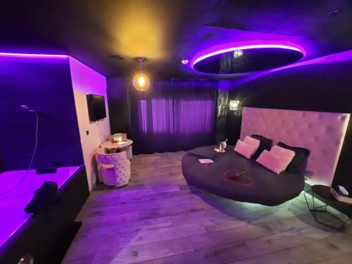 fioletowy pokój z łóżkiem i stołem w obiekcie Nuits Blanches w mieście Liège