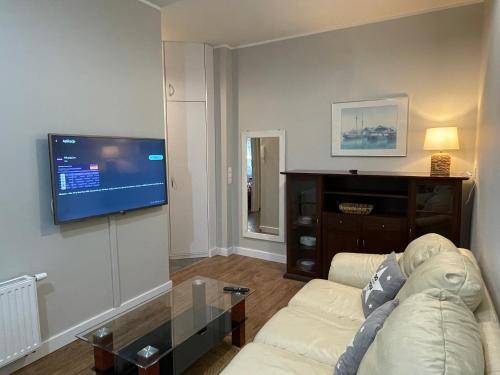 een woonkamer met een bank en een flatscreen-tv bij Home3city Przytulny in Sopot