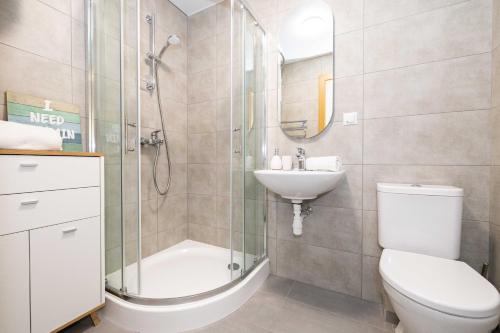 a bathroom with a toilet and a sink and a shower at Aqua Apartment Šventovė, By Cohost in Palanga