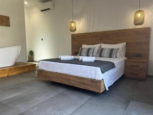 een slaapkamer met een groot bed en een bad bij Sydney Hotel in Kefalos