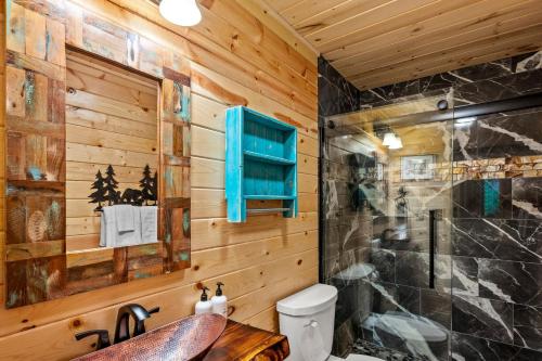 a log cabin bathroom with a sink and a shower at Sunrise View Chalet in Gatlinburg