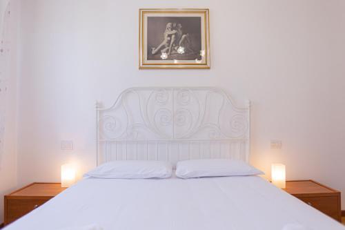 a bedroom with a large white bed with two lamps at La terrazza di Giulietta in San Giovanni Lupatoto