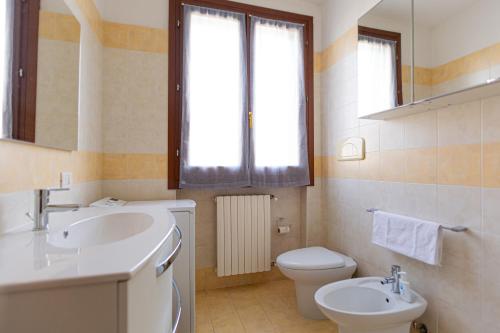 a bathroom with a sink and a toilet and a window at La terrazza di Giulietta in San Giovanni Lupatoto
