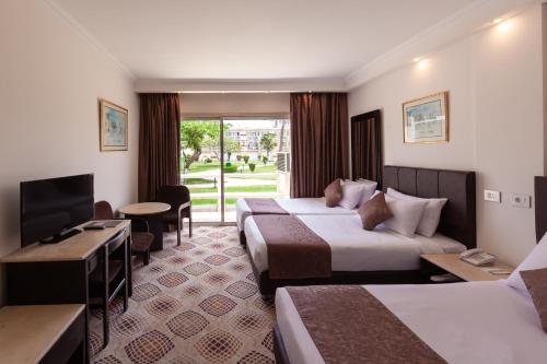 um quarto de hotel com duas camas e uma televisão em Pyramids Park Resort Cairo no Cairo