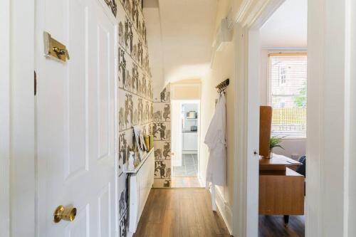 un pasillo de una casa con paredes blancas y suelo de madera en Garden Apartment in Listed Building, en Leamington Spa