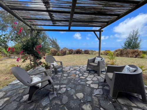 a group of chairs and tables on a patio at COCO MANGO Villa in Trèfles