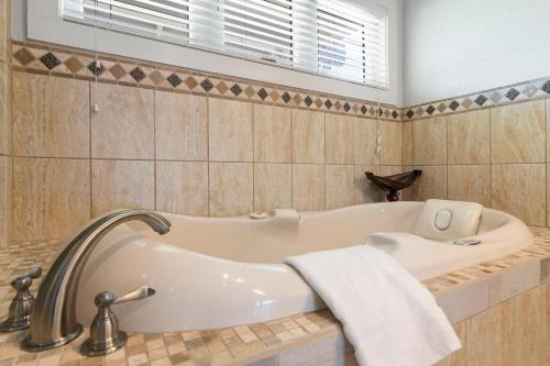 a bathroom with a bath tub and a sink at Lake Escape Lakefront Lodge at Red Bud Cove in Hollister