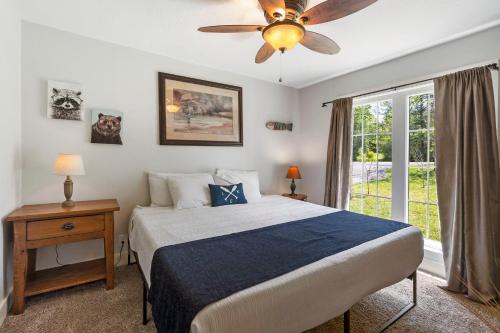 a bedroom with a bed and a ceiling fan at Lake Escape Lakefront Lodge at Red Bud Cove in Hollister