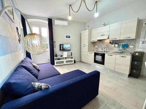 salon z niebieską kanapą i kuchnią w obiekcie Cà del Mar - La Spezia e Cinque Terre w mieście La Spezia