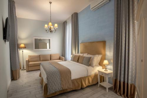 1 dormitorio con 1 cama y 1 sofá en Baldassini Suites, en Roma