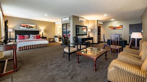 a hotel room with a bed and a living room at African Sky Hotels - Pine Lake Inn in White River