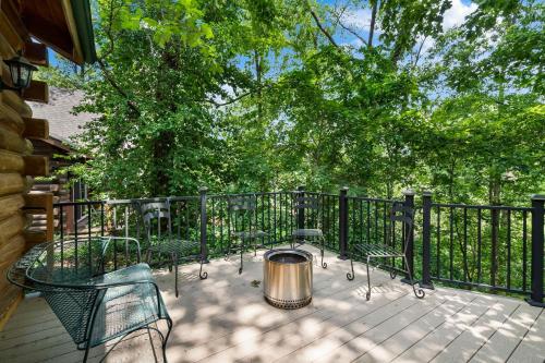 a deck with chairs and a trash can next to a fence at Dogwood Tree Cabin in Ridgedale