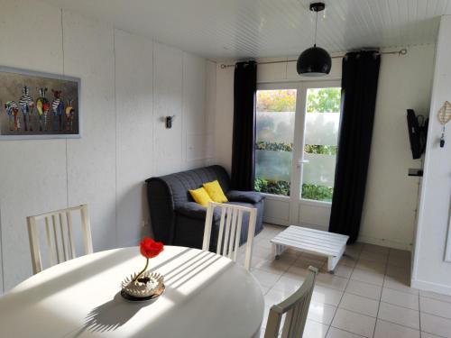 sala de estar con mesa y sofá en Chalet 38 m2, au calme reposant, près du puy /fou, en Saint-Pierre-des-Échaubrognes