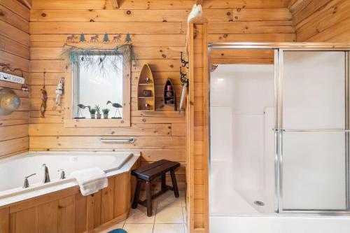 a bathroom with a tub and a shower at Dogwood Tree Cabin in Ridgedale