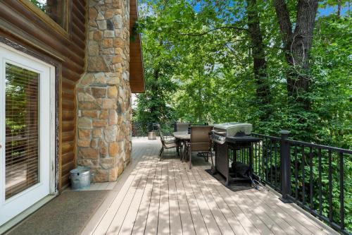a porch with a grill and a table and chairs at Dogwood Tree Cabin in Ridgedale
