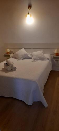 a bedroom with a white bed with two lights on it at Paradise, Porto Saler ET7104 in La Savina
