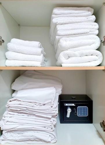 a closet with white towels on a shelf at Hantke28 Budget Apartment in Haifa
