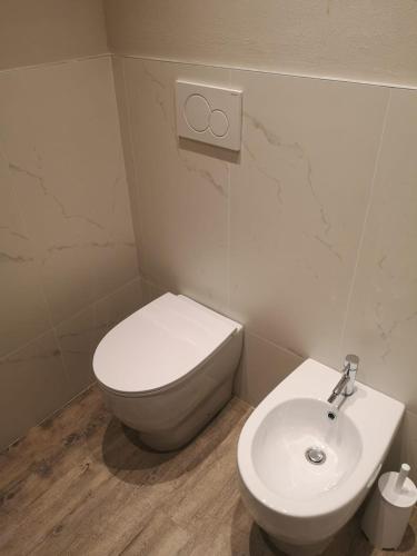 a bathroom with a white toilet and a sink at Suite Apartments in Cervia