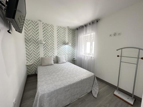 een kleine slaapkamer met een bed en een raam bij Casa na Vila by Trip2Portugal in Figueiró dos Vinhos