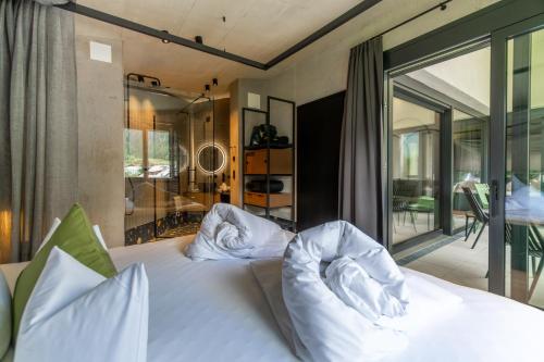 a bedroom with a white bed and a balcony at Lifesteil Aparthotel in Umhausen