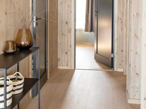 pasillo con puerta a una cocina con paredes de madera en Holiday home INDERØY, 
