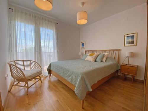 1 dormitorio con 1 cama, 1 silla y 1 ventana en Fontanilla 58 Casa Lucia with pool and garage at Playa Conil, en Conil de la Frontera