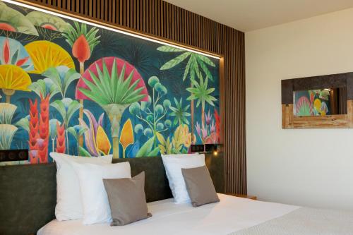 1 dormitorio con 1 cama con una pintura en la pared en Hotel Costa Salina, en Porto Vecchio