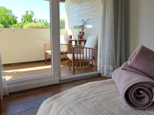 a bedroom with a sliding glass door to a patio at Lavender Garden House in Rogoznica