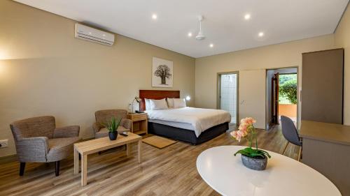 a hotel room with a bed and a table and chairs at African Sky Hotels - Pine Lake Inn in White River