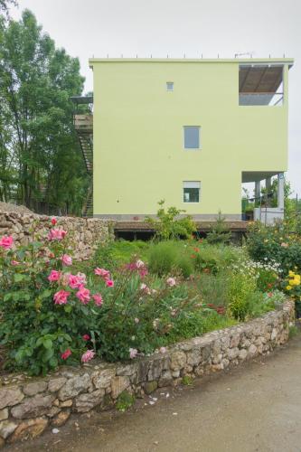 a stone wall with flowers in front of a building at Irina in Soko Banja