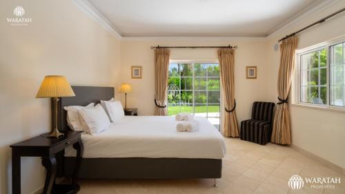 Un dormitorio con una cama grande y una ventana en Villa Susana, en Quinta do Lago
