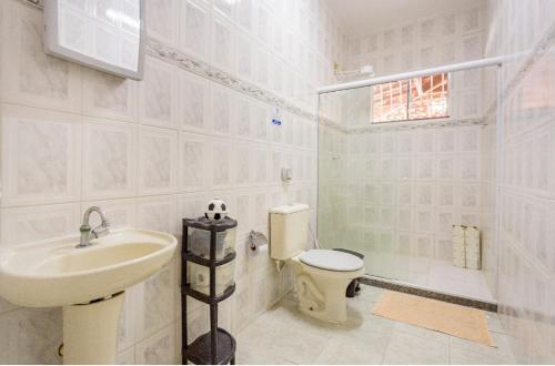 La salle de bains est pourvue d'un lavabo, de toilettes et d'une douche. dans l'établissement Casa aconchegante à 200m da praia, à Rio das Ostras