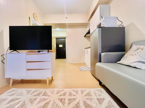 uma sala de estar com uma televisão e um sofá em * * * J Travellers' Choice 2023 em Iloilo