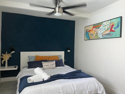 a bedroom with a bed with a blue accent wall at Busch Gardens Bliss Suite -1 in Tampa