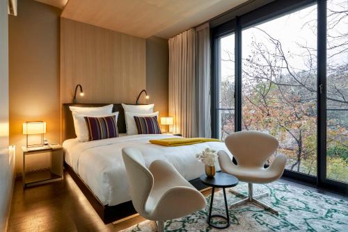 a bedroom with a bed and a large window at SO/ Berlin Das Stue in Berlin