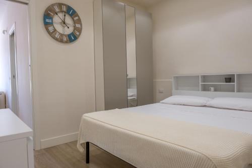 a bedroom with a bed and a clock on the wall at Teatro Apartments Mondello in Palermo