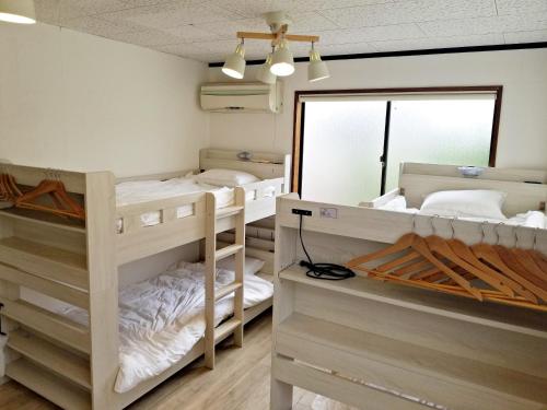 two bunk beds in a room with a mirror at Guest House Tatara in Yasugi